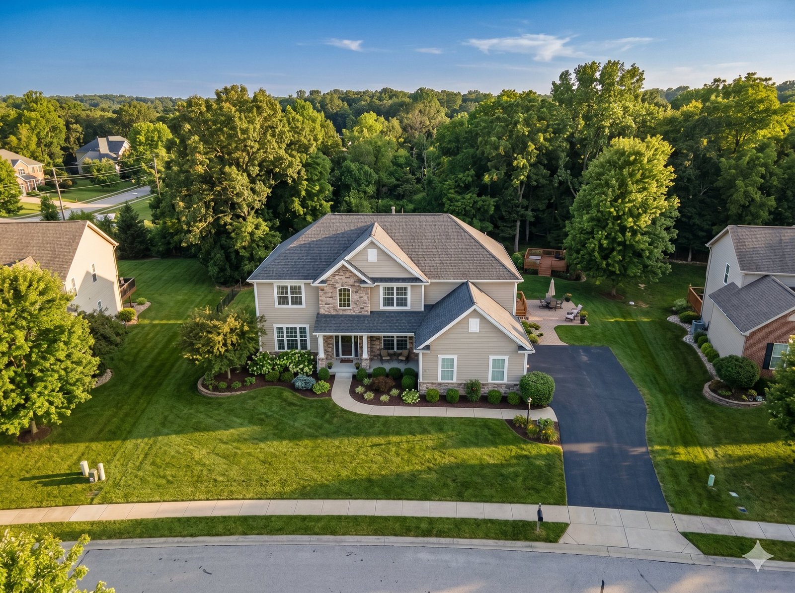 Drone aerial view of a two-story suburban home showing full property, lot, mature trees, and neighborhood context in golden hour light